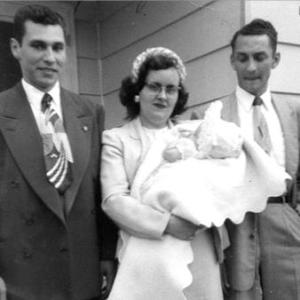 This cropped photograph from Ilene's 1957 baptism includes - from left to right: Puzzy, the uncle and godfather; Donna, the mom holding infant Ilene; and Dave, the father.