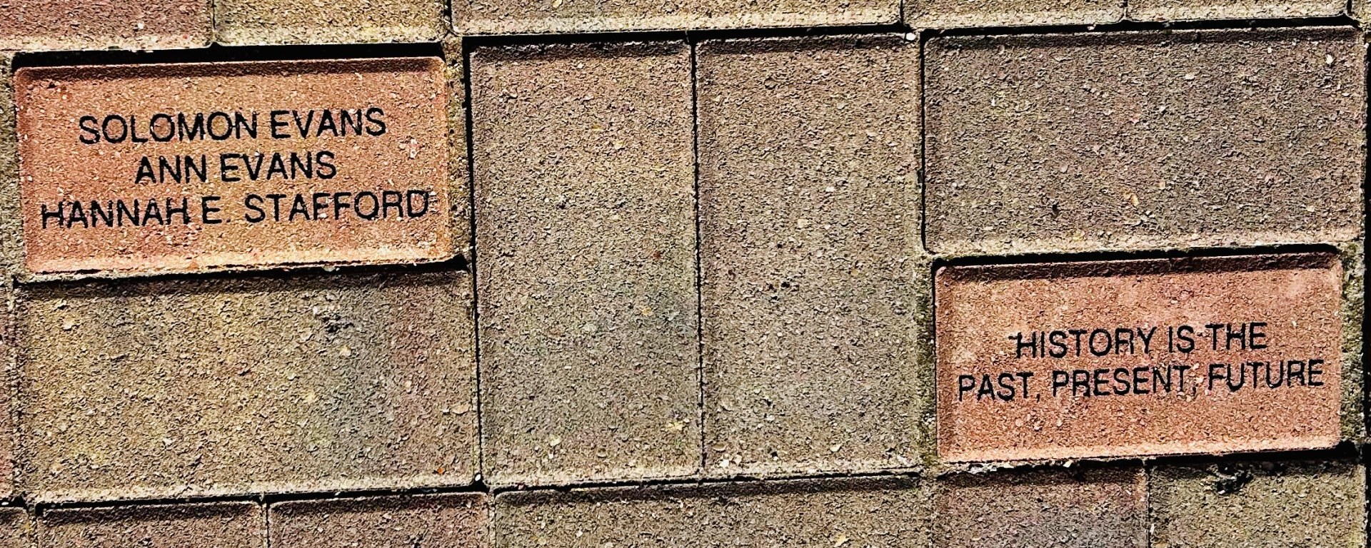 Paving stones just outside the Blue Earth Country Historical Society entrance. One is inscribed with the names Solomon Evans, Ann Evans, and Hannah E. Stafford. The other with the saying "History is the past, present, future.
