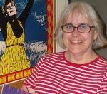 Photo of Ilene in her office, sat in front of a poster protesting the closure of coal mines in Australia.